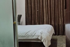 A room with a bed, a door, and curtains. - 116 Business Hostel (Chongqing)
