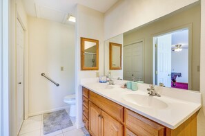 A bathroom with two sinks, wooden cabinets, a large mirror, and a shower area. - Vacation Home With Breathtaking Views, Ample Parking and Pool Table (Cañon City)