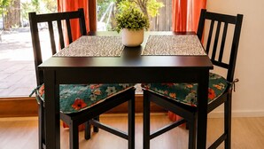 Una mesa de comedor con sillas, una planta en maceta y una lámpara colgante.