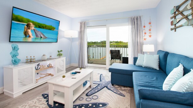 A living room with a TV, sofa, and coffee table. - Intracoastal Waterways / Dolphin Sighting / YTC Resort (Indian Shores)
