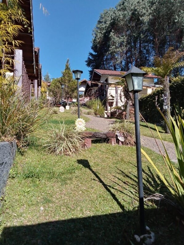 Ein Garten mit einem Weg, der zu einem Gebäude mit einem geneigten Dach führt.