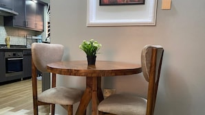 A dining area with a round wooden table and two upholstered chairs.