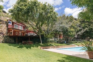 Una piscina al aire libre, sombrillas, sillones reclinables de piscina