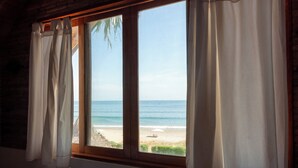 Una habitación con un amplio ventanal con vistas a la playa.