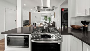 A modern kitchen with a central island, built-in oven, and stainless steel appliances. - Delightful & Comfy 2-Bedroom in Ocean Beach with BBQ Grill (San Diego)