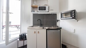 Una cocina compacta equipada con microondas, lavavajillas y una pequeña encimera.