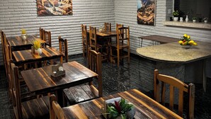 A dining area with wooden tables and chairs, a bar counter, and two large paintings on the walls.