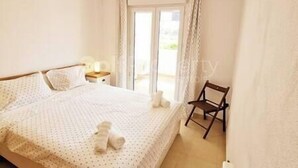 Ein Schlafzimmer mit einem Bett, einem Sessel und einem Fenster.