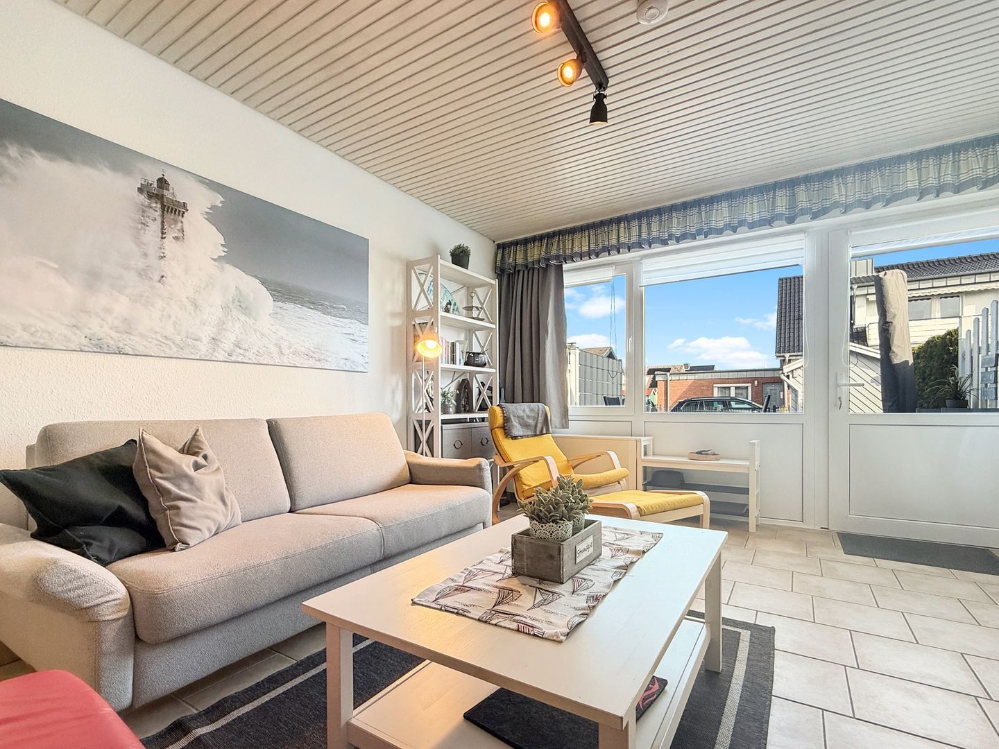 Ein Wohnzimmer mit Sofa, Couchtisch, Stuhl und Bücherregal.