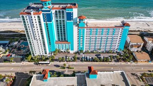 A large hotel with multiple towers, a beach, and a parking lot. - Caribbean 2002 (Myrtle Beach)