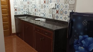 A kitchen with a tiled backsplash, a sink, and a refrigerator. - Serene  and very friendly Village settings.
Spacious and homely Atmosphere  (Kolve)