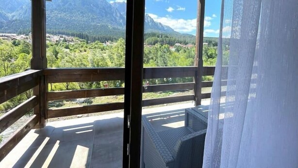 A balcony with a view of mountains and greenery. - Alpine River Home: Peace and Mountain View (Bușteni)