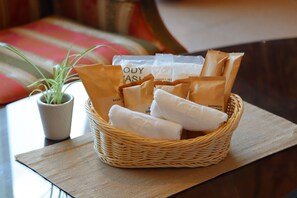 A wicker basket on a table containing toiletries, including a plant and a tissue box. - Grand Empire Hotel (Oonojo)