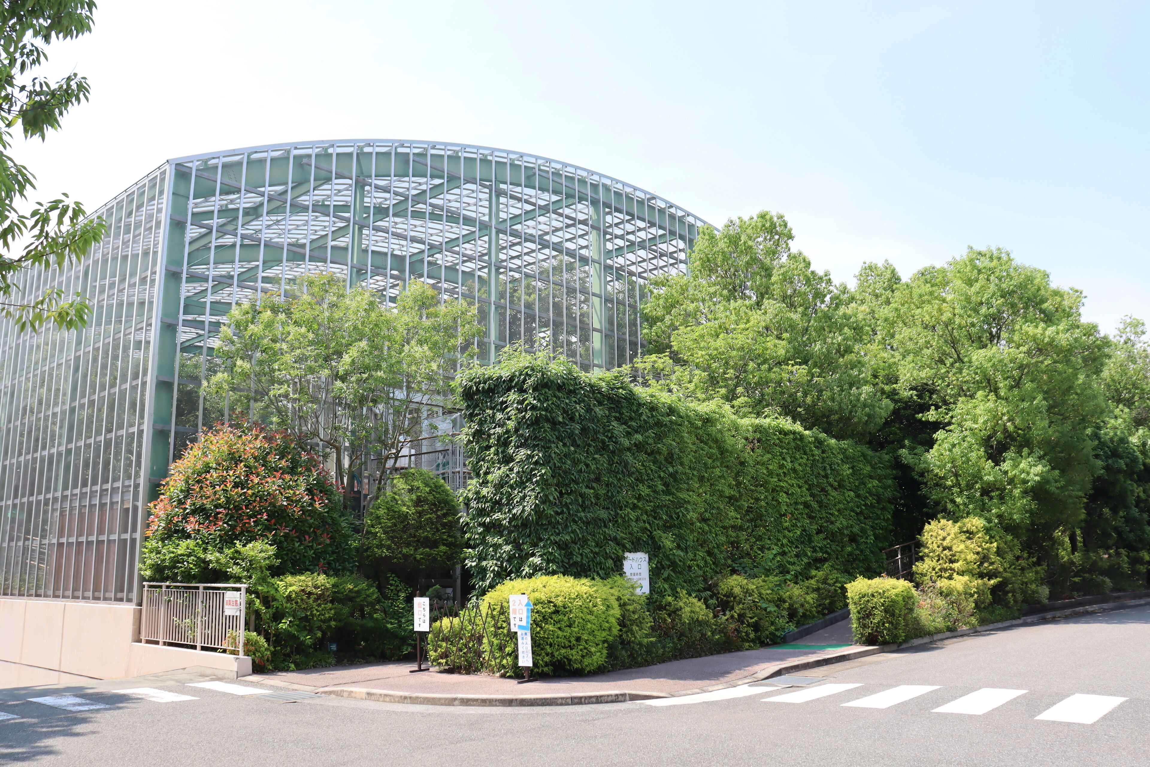 A modern building with a glass facade and a curved structure.