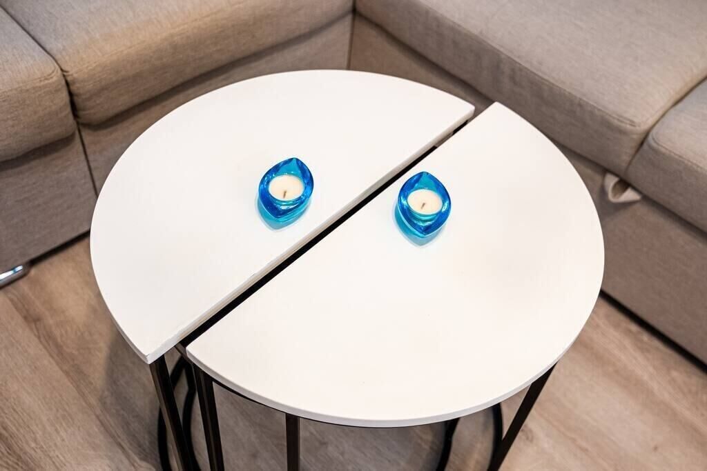 A round white table with two blue candle holders on it.