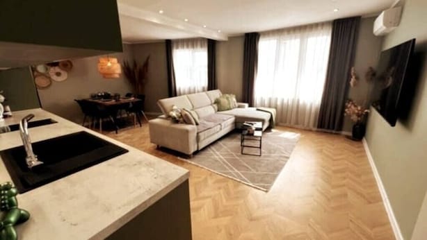 Una sala de estar moderna con un sofá, una mesa de centro y un comedor con una mesa y sillas.