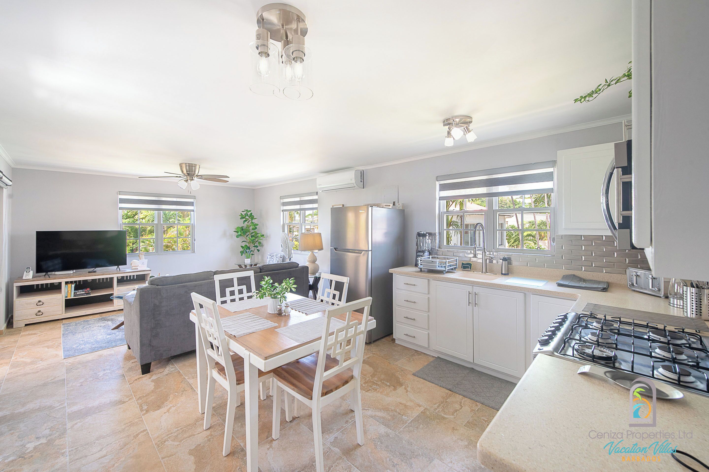 A spacious kitchen with a dining area, modern appliances, and large windows.