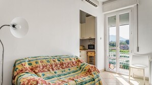 Ein Zimmer mit einem Bett, einem kleinen Tisch, einem Fernseher und einem Balkon mit Blick.