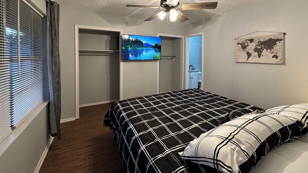 Ein Schlafzimmer mit Bett, Deckenventilator, Fernseher und einer Weltkarte an der Wand.