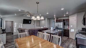 Une cuisine moderne avec un coin repas, un plancher en bois et un ventilateur de plafond.