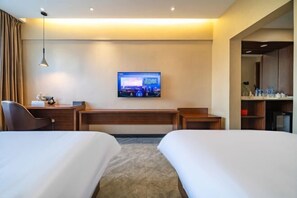 A hotel room with two beds, a desk, a chair, a TV mounted on the wall, and a minibar. - Zhengzhou University Institute of Technology Hotel (Zhengzhou)