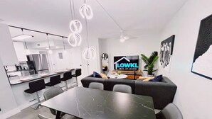 A modern kitchen with a built-in oven and a dining area with a marble table and chairs. - Bright 3-Bedroom 3 Bath Apt with Pool, Parking, & Close to Beach & Las Olas (Fort Lauderdale)