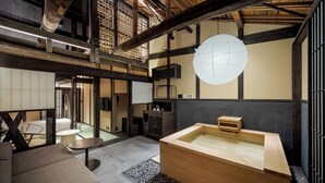 Een traditionele Japanse kamer met tatami vloerbedekking, een houten badkuip en een hangende papieren lantaarn.