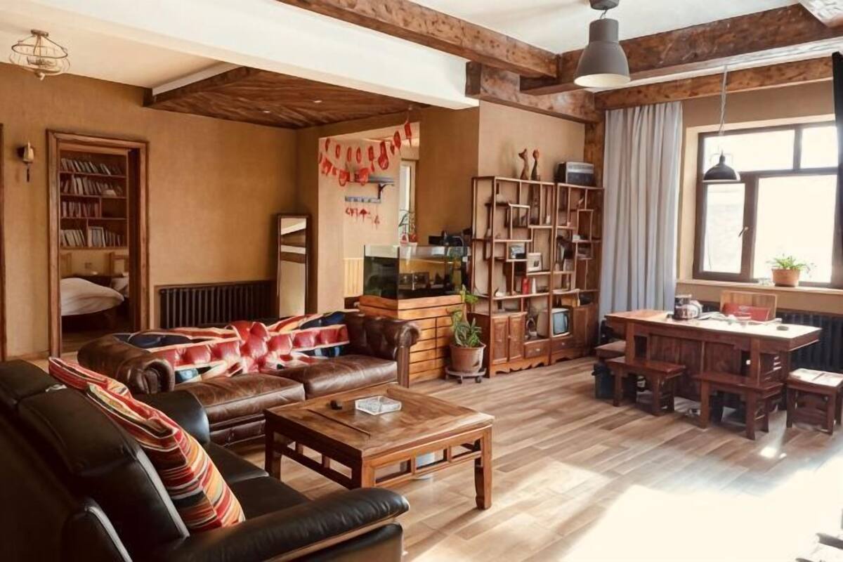 Een gezellige woonkamer met een bank, salontafel en boekenplanken.