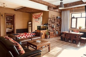 A cozy living room with a sofa, coffee table, and bookshelves. - Yabuli Yabuluoni Private Villa (Shangzhi)