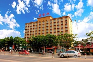 A multi-story hotel with a prominent entrance, surrounded by trees and a clear sky. - Dongfang Tanggula Hotel (High-speed Railway Station) (Dongfang)