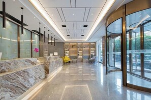 A modern hotel lobby with a marble reception desk, seating area, and large windows. - Molin Collection Hotel (Liuyang Haoting) (Liuyang)