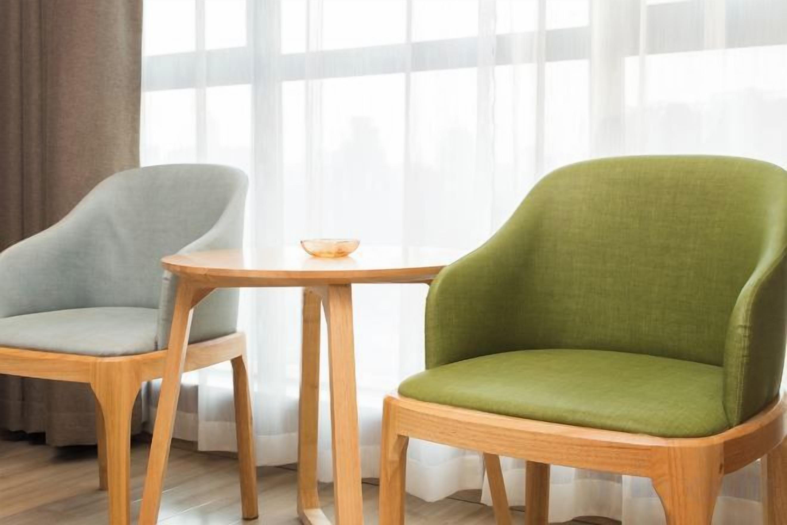 Dos sillas con estructura de madera y una mesita con un cuenco.
