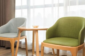 Two chairs with wooden frames and a small table with a bowl. - Molin Collection Hotel (Liuyang Haoting) (Liuyang)