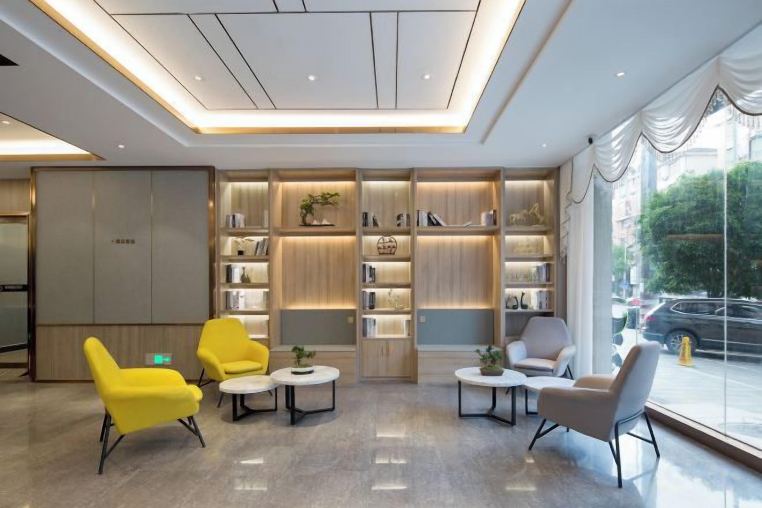 A modern lobby with seating, bookshelves, and a large window.