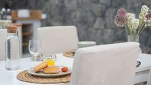 A breakfast setting with a plate of pastries, a glass of orange juice, and a bottle of water on a table. - Luxury House 'La Cueva del Guanche' with Sea Views, Private Pool & Wi-Fi (Adeje)