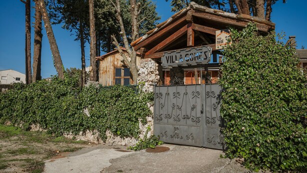 Un edificio rústico de madera con un cartel que dice 'Villa Gomez'.