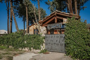 Un edificio rústico de madera con un cartel que dice 'Villa Gomez'.