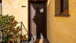 A wooden door with a sign above it, a small window to the right, and a metal railing to the left. - Country House 'Alojamiento Perseus' with Mountain View, Balcony and Wi-Fi (Braojos de la Sierra)