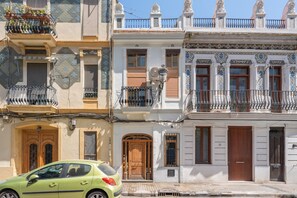 Une rangée de bâtiments de style européen traditionnel, dotés de balcons, de portes en bois et de carreaux décoratifs.