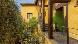 A yellow building with a balcony, a staircase, and a small window. - Country House 'Alojamiento Hercules' with Mountain View, Balcony and Wi-Fi (BRAOJOS)
