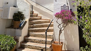 A white building with a staircase leading to a second-floor balcony.