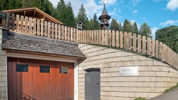 Un edificio con recinzione in legno, un garage e un cartello con la scritta 'Solinda'.