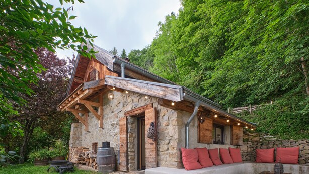 A rustic stone building with a wooden porch, stone walls, and a stone bench with red cushions. - Holiday Home 'L'atelier M' with Mountain View, Private Terrace and Garden (Quaix-en-Chartreuse)