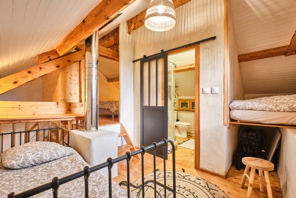 A loft bedroom with a bunk bed, a desk, and a bathroom visible through an open door. - Holiday Home 'L'atelier M' with Mountain View, Private Terrace and Garden (Quaix-en-Chartreuse)