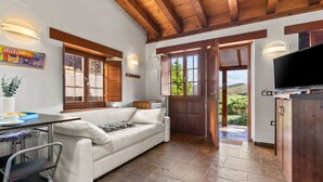 Un intérieur moderne avec un canapé blanc, un plafond en bois et un téléviseur.