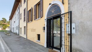 Un edificio con un gran portón negro, un logotipo con un árbol y un letrero que dice 'KEVITA ROOMS'.