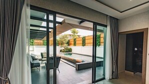 A modern interior with a sliding glass door leading to an outdoor patio area. - Astro Luxury: 4-6 beds Ultra Luxury Pool Villa with Daily Cleaning (Pattaya)