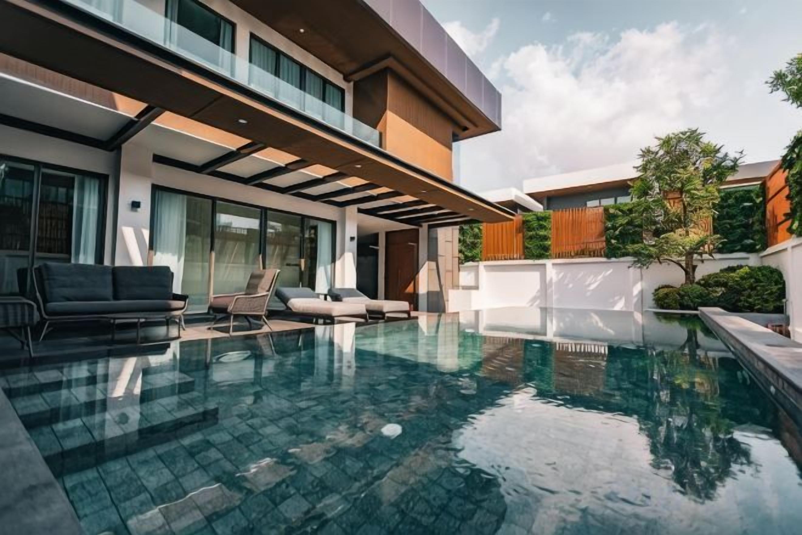 Una casa moderna con piscina, area salotto esterna e un'ampia finestra vista piscina.