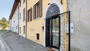 A building with a large black gate, a tree logo, and a sign reading 'KEVITA ROOMS.'