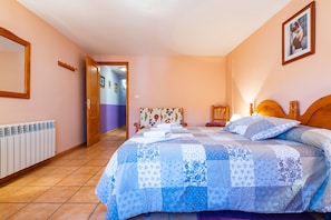 Quarto com cama, radiador, porta e corredor.
